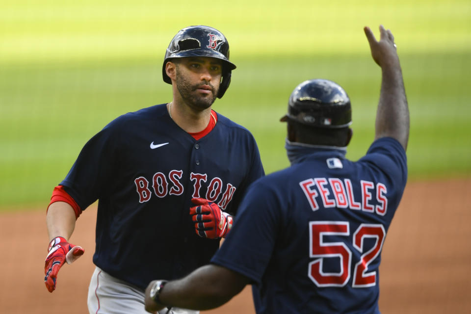 Boston Red Sox's J.D. Martinez, left, is congratulated by third base coach Carlos Febles as he runs bases during a two-run home run over center field the seventh inning of a baseball game against the Atlanta Braves, Sunday, Sept. 27, 2020, in Atlanta. (AP Photo/John Amis)