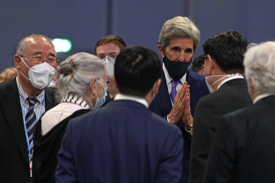 China's chief negotiator Xie Zhenhua, left, looks on as John Kerry, United States Special Presidential Envoy for Climate gestures as he talks to Japanese delegates during a stocktaking plenary session at the COP26 U.N. Climate Summit in Glasgow, Scotland, Saturday, Nov. 13, 2021. Going into overtime, negotiators at U.N. climate talks in Glasgow are still trying to find common ground on phasing out coal, when nations need to update their emission-cutting pledges and, especially, on money. (AP Photo/Alastair Grant)