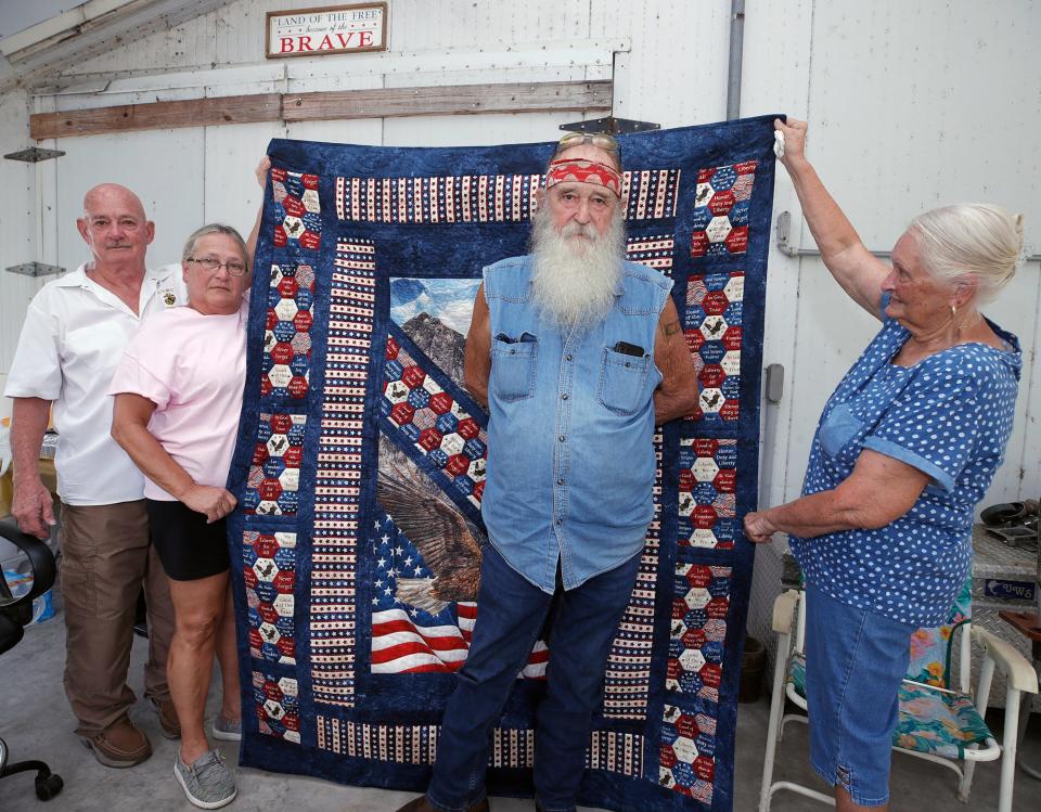 Jackie Miller receives his "Quilt of Honor" at a ceremony in his DeLand home on Thursday. Miller is a U.S. Navy Seabee Vietnam veteran and Purple Heart recepient.