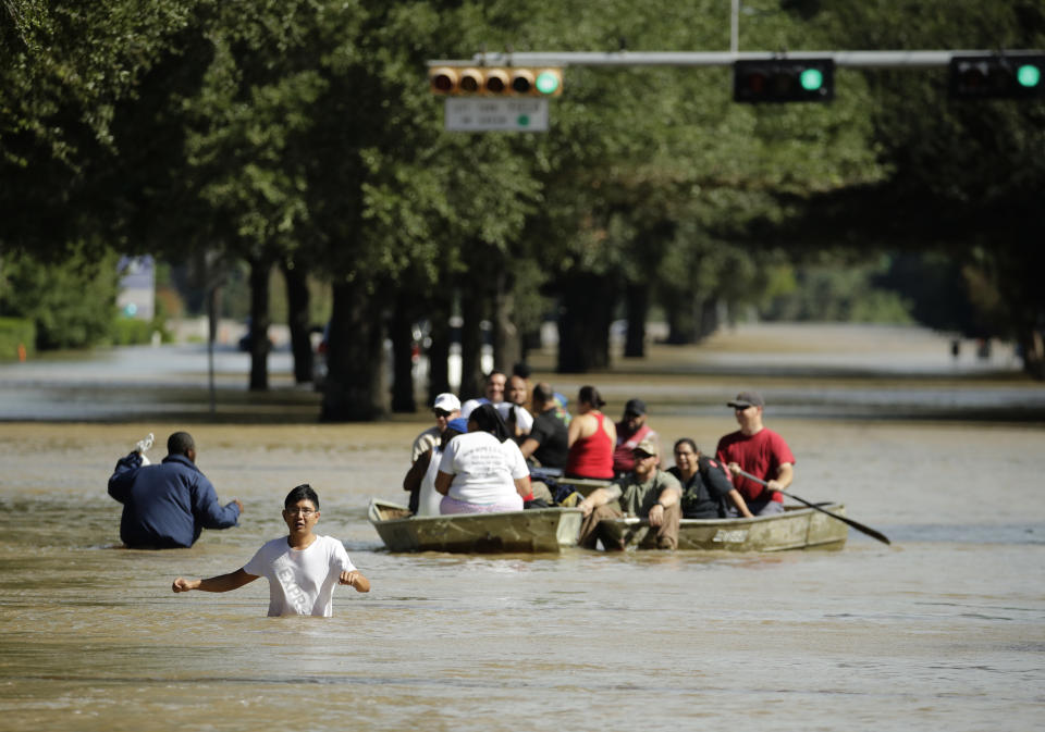 <em>People evacuate a neighborhood inundated after water was released from nearby Addicks Reservoir (AP)</em>