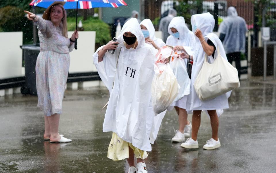 Umbrellas and ponchos were key fashion accessories at Royal Ascot on day four - PA