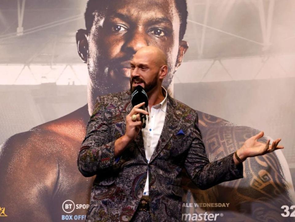 Tyson Fury speaks at a press conference in front of a poster of Dillian Whyte (AFP via Getty Images)