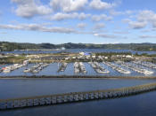 In this July 22, 2019, photo, Oregon State University's Marine Studies Building, which is under construction in a tsunami inundation zone, is seen from the Yaquina Bay Bridge in Newport, Ore. The building, slightly right of center in the middle of the photograph, is surrounded by Yaquina Bay. Construction workers in this Oregon coastal town are erecting the building right in the path of a future tsunami that experts say will be generated by a huge offshore earthquake that is certain to occur sooner or later. (AP Photo/Andrew Selsky)