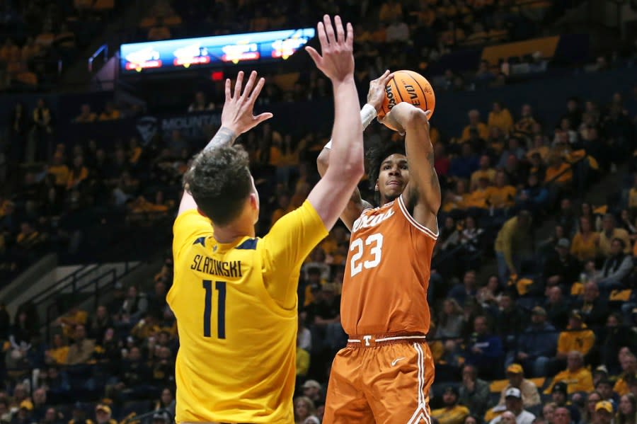 Texas forward Dillon Mitchell (23) is defended by West Virginia forward Quinn Slazinski (11) during the second half of an NCAA college basketball game on Saturday, Jan. 13, 2024, in Morgantown, W.Va. (AP Photo/Kathleen Batten)