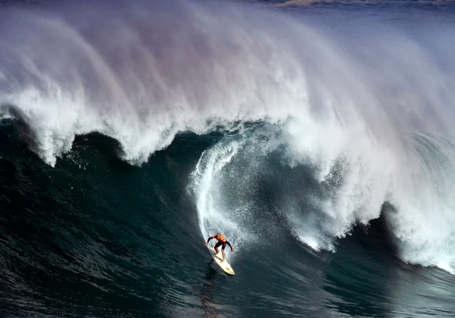 <em>Kelly Slater surfs in the In Memory of Eddie Aikau big wave surf contest on the North Shore at Waimea Bay near Haleiwa, Hawaii. (Michael Goulding/The Orange County Register via AP, File)</em>