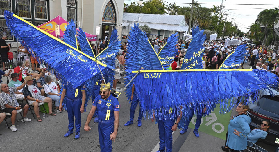 In this Friday, Oct. 27, 2023, photo provided by the Florida Keys News Bureau, Daniel Bitnar, center, leads a blue-winged group depicting the U.S. Navy's elite Blue Angels Flight Demonstration Squadron in the Fantasy Fest Masquerade March in Key West, Fla. Thousands of Florida Keys residents and visitors participated in the procession, a highlight of the 10-day Fantasy Fest costuming and masking extravaganza that concludes Sunday, Oct. 29. The festival's 2023 theme is "Uniforms and Unicorns … 200 Years of Sailing into Fantasy," chosen to salute the Florida Keys' bicentennial and that of the U.S. Navy in Key West. (Andy Newman/Florida Keys News Bureau via AP)