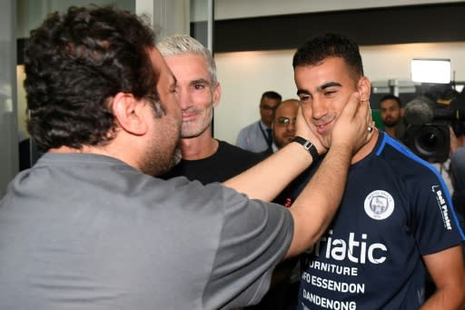 Hakeem al-Araibi (R) was greeted by a crowd of supporters including former Australian football captain Craig Foster (C) who led a campaign for his release