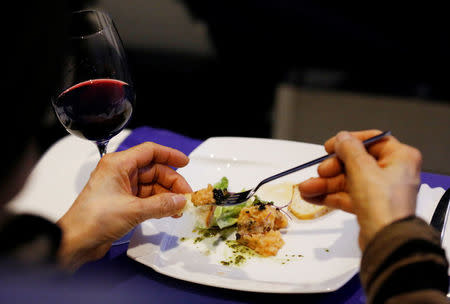 A guest eats first-class meal at the "First Airlines", virtual first-class airline experience facility in Tokyo, Japan February 14, 2018. Picture taken February 14, 2018. REUTERS/Toru Hanai