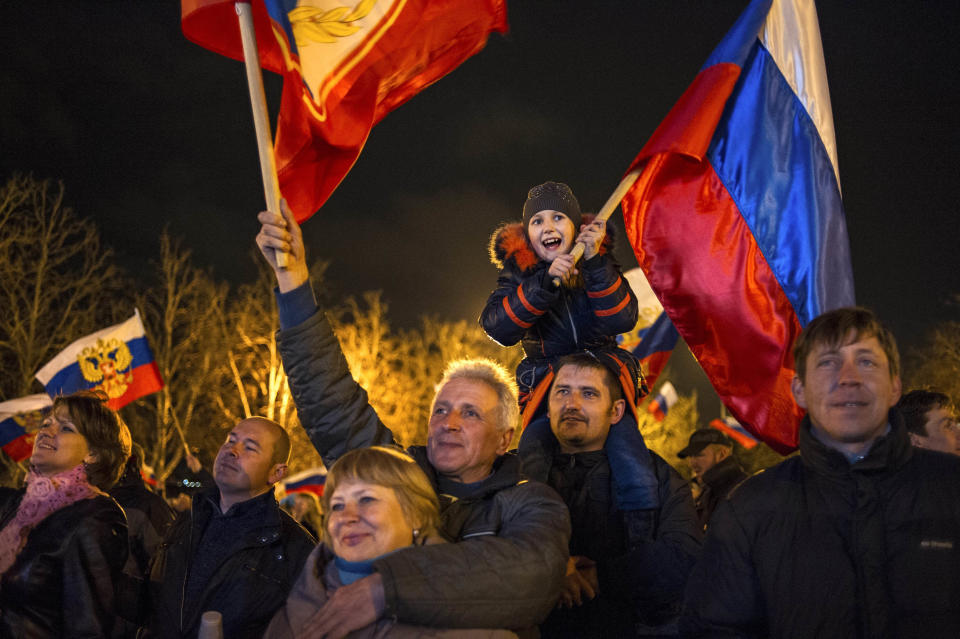 Pro-Russian people celebrate in the central square in Sevastopol, Ukraine, early Monday, March 17, 2014. Russian flags fluttered above jubilant crowds Sunday after residents in Crimea voted overwhelmingly to secede from Ukraine and join Russia. The United States and Europe condemned the ballot as illegal and destabilizing and were expected to slap sanctions against Russia for it.(AP Photo/Andrew Lubimov)