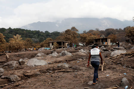 Eufemia Garcia, 48, who lost 50 members of her family during the eruption of the Fuego volcano, walk on top what use to be houses to find the area where it was her house and then search for her family in San Miguel Los Lotes Escuintla, June 9, 2018. Picture taken June 9, 2018.REUTERS/Carlos Jasso