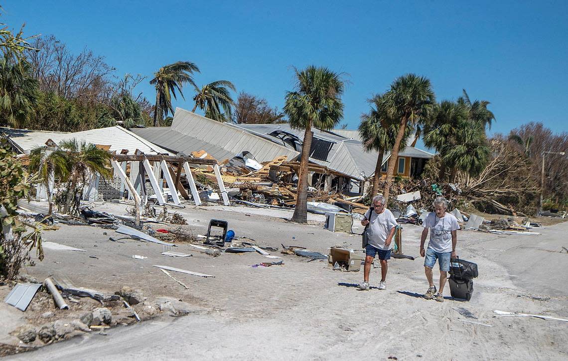 Residents walk along Estero Boulevard with suitcases as they leave the Fort Myers Beach Island, two days after Hurricane Ian hit Florida’s west coast as a Category 4 storm, on Friday September 30, 2022.