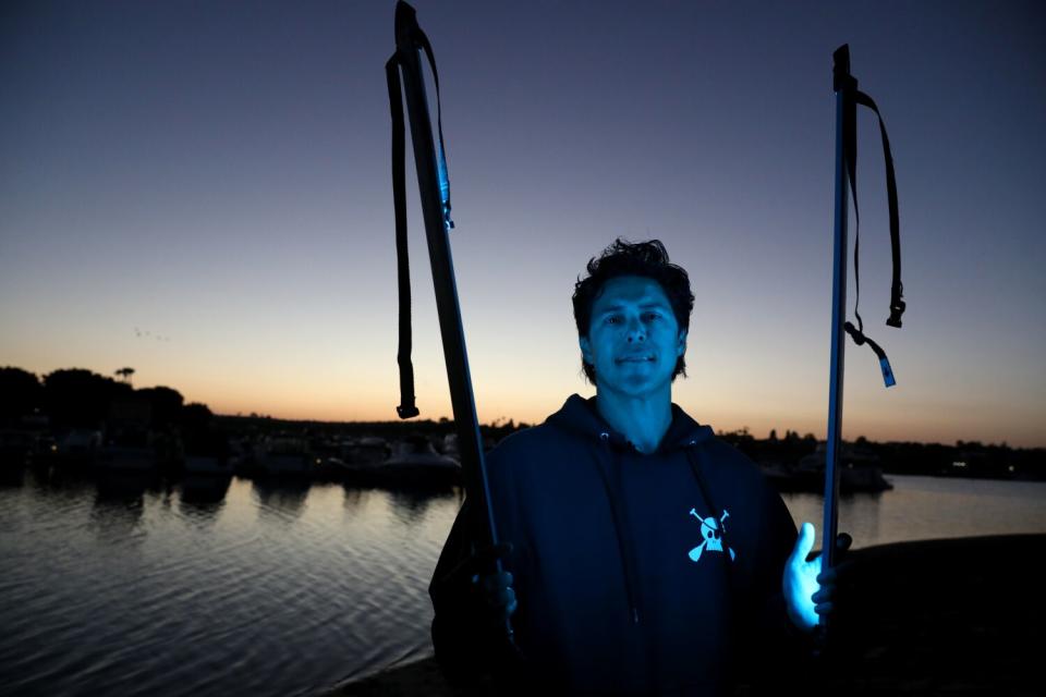 A man at dusk in the glow of LED light.