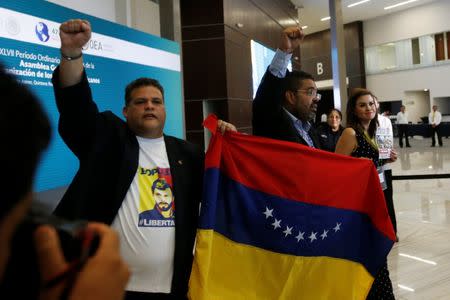 Venezuelan opposition lawmakers Franco Casella and Wilson Flores protest inside the venue where the Organization of American States (OAS) 47th General Assembly is taking place in Cancun, Mexico June 21, 2017. REUTERS/Carlos Jasso