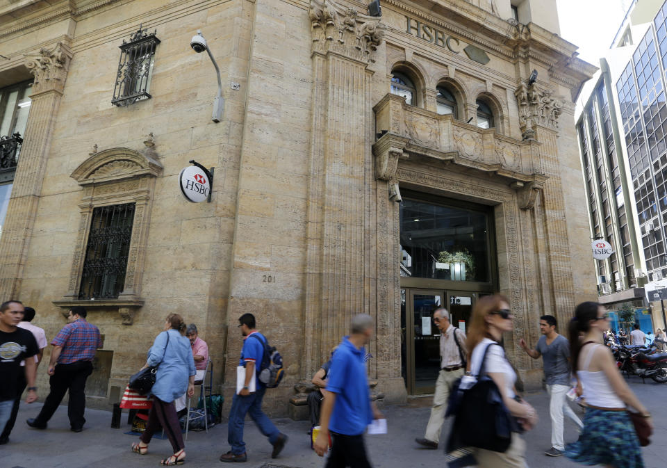 Pedestrians walk past a main branch of HSBC bank in downtown Buenos Aires February 12, 2015. Britain has asked Argentina for information about the South American country's investigation into HSBC Holdings, Buenos Aires said on Wednesday, part of a widening probe into allegations that the bank helped clients dodge taxes. Early this week a panel of British lawmakers said they planned to open an inquiry into the British bank after media reports that it helped wealthy customers conceal assets. In November Argentina charged HSBC with helping more than 4,000 clients evade taxes by stashing their money in secret Swiss bank accounts. HSBC Argentina rejected the charge, saying it respected Argentine law.    REUTERS/Enrique Marcarian (ARGENTINA - Tags: POLITICS BUSINESS)