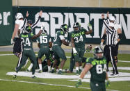 Michigan State players celebrate after scoring a touchdown on a fumbled Northwestern lateral as time expires during the fourth quarter of an NCAA college football game, Saturday, Nov. 28, 2020, in East Lansing, Mich. (AP Photo/Al Goldis)