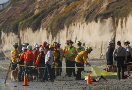 Emergency responders attend to a cliff collapse at a beach in Encinitas, California