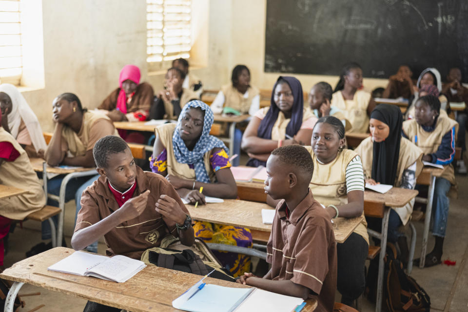 Mouhamed Sall, who is deaf, communicates using sign language at the Guinaw Rail Sud public high school in Pikine, Senegal, Monday, March 18, 2024. Sall and three other students are part of a new approach in a small number of schools in Senegal that seat those who are deaf and hard of hearing with the rest of the class. (AP Photo/Sylvain Cherkaoui)