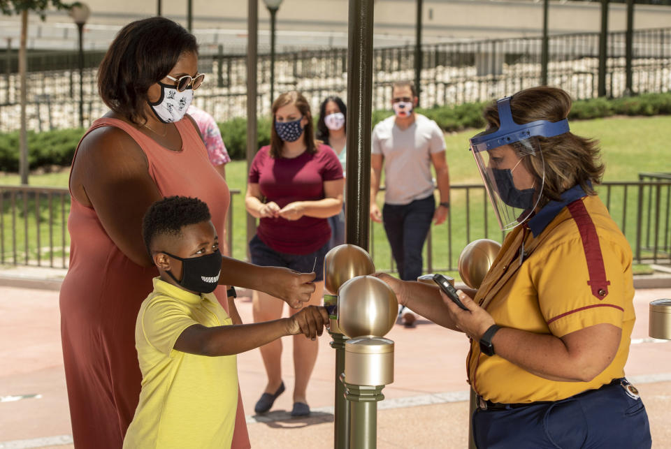 Cast members who continuously interact with guests at Walt Disney World Resort theme parks in Lake Buena Vista, Fla., such as seen here at the main entrance of Magic Kingdom Park, will wear both face coverings and face shields when the theme parks begin their phased reopening July 11, 2020. (Disney/Kent Phillips, photographer)