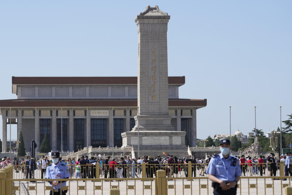 Chinese policemen stand on duty as tourists visit Tiananmen Square on the 32nd anniversary of a deadly crackdown on pro-democracy protests in Beijing on Friday, June 4, 2021. Commemorations of the June 4, 1989 crackdown on student-led pro-democracy protests centered on Beijing's Tiananmen Square were especially muted Friday amid pandemic control restrictions and increasing political repression. (AP Photo/Ng Han Guan)