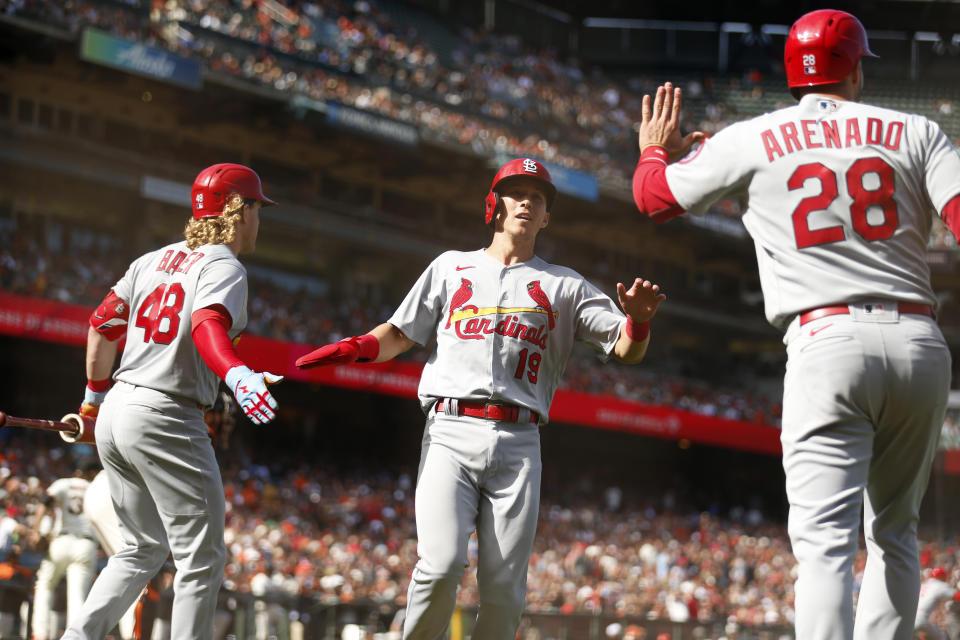 CORRECTS TO SEVENTH INNING NOT FIRST INNING - St. Louis Cardinals' Tommy Edman, center, is congratulated by teammates Harrison Bader, left, and Nolan Arenado, right, after scoring on a triple hit by Matt Carpenter against the San Francisco Giants during the seventh inning of a baseball game in San Francisco, Monday, July 5, 2021. (AP Photo/Jed Jacobsohn)