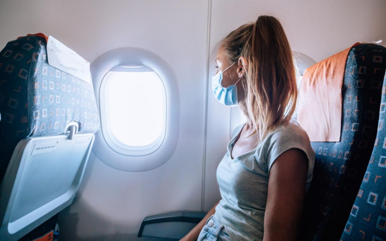 Woman traveling by plane during Coronavirus pandemic - lncreativemedia/Getty