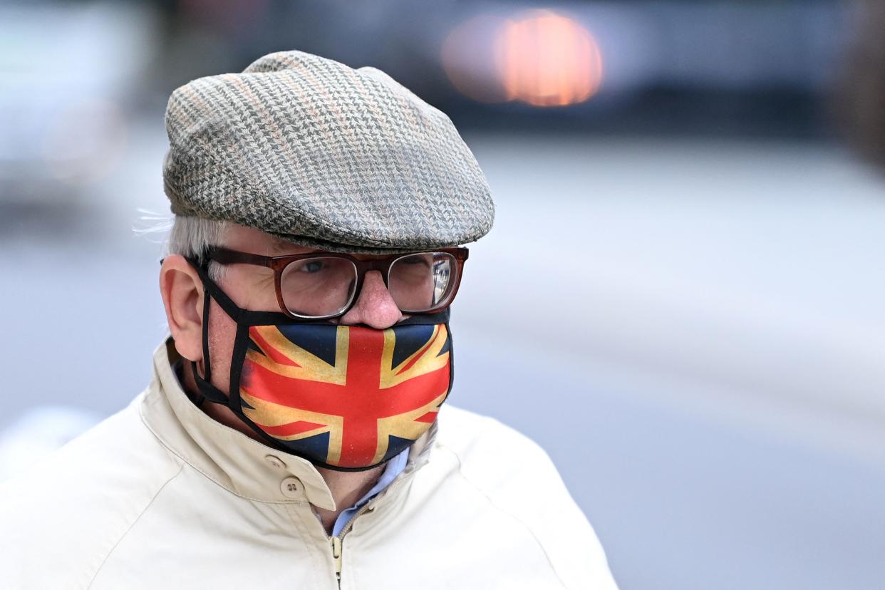 A man wears a Union flag-themed face covering, as a precation against the spread of Covid-19, as he walks along a street in London on September 30, 2021. (Photo by DANIEL LEAL-OLIVAS / AFP) (Photo by DANIEL LEAL-OLIVAS/AFP via Getty Images)