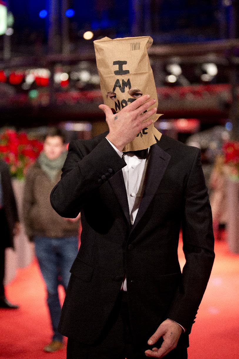 FILE - In this Sunday, Feb. 9, 2014 file photo, actor Shia LaBeouf poses for photographers on the red carpet for the film "Nymphomaniac" at the International Film Festival Berlinale, in Berlin. LaBeouf began his planned seven-hour, seven-day stint inside the Stephen Cohen Gallery in Los Angeles on Tuesday, Feb. 11, 2014, seated at a small table, wearing a disheveled tuxedo and the paper bag with some eye holes cut out and the words "I AM NOT FAMOUS ANYMORE" scrawled in black ink across it. LaBeouf's performance-art oddity comes days after he posed on the red carpet at the Berlin Film Festival in the same getup and walked out of a press conference to promote filmmaker Lars von Trier's "Nymphomaniac Volume I." (AP Photo/Axel Schmidt, file)