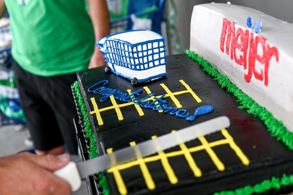 A cake with a shopping cart is cut during a celebration for Dave Esch on Wednesday, July 20, 2022, at the Meijer in Grand Ledge. Esch was celebrated for returning his millionth shopping cart as an employee of the store.