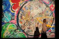 A visitor walks past a painting by the British artist Sacha Jafri at the Atlantis hotel in Dubai