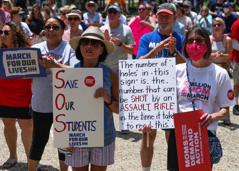 Michele Smith, center, and Kim Smith, right, make their feelings known during Mayor Greg Fischer's speech at a rally against gun violence in downtown Louisville, Kentucky, on June 11, 2022.