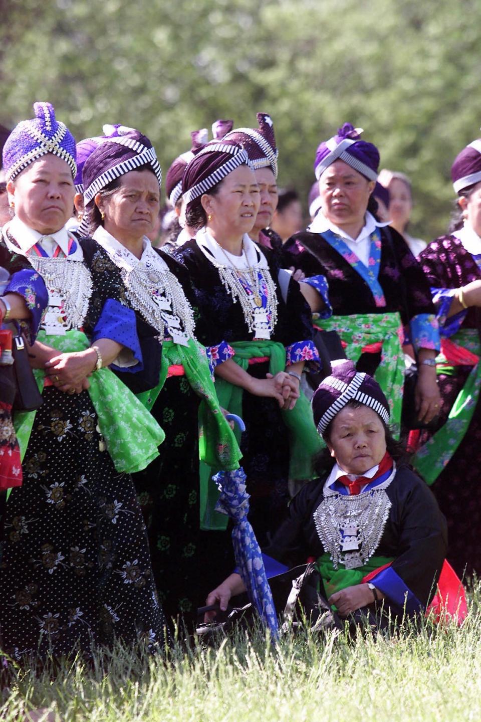 Hmong women wearing formal dresses used for special events, watching as Hmong and other Laotian-born vietnam veterans march to the Vietnam Veterans Memorial to mark the 25th anniversary of the end of the Vietnam War, Thursday morning in Washington, D.C. The color of the dresses indicate the village from which they come. (GNS Photo by Heather Martin Morrissey)