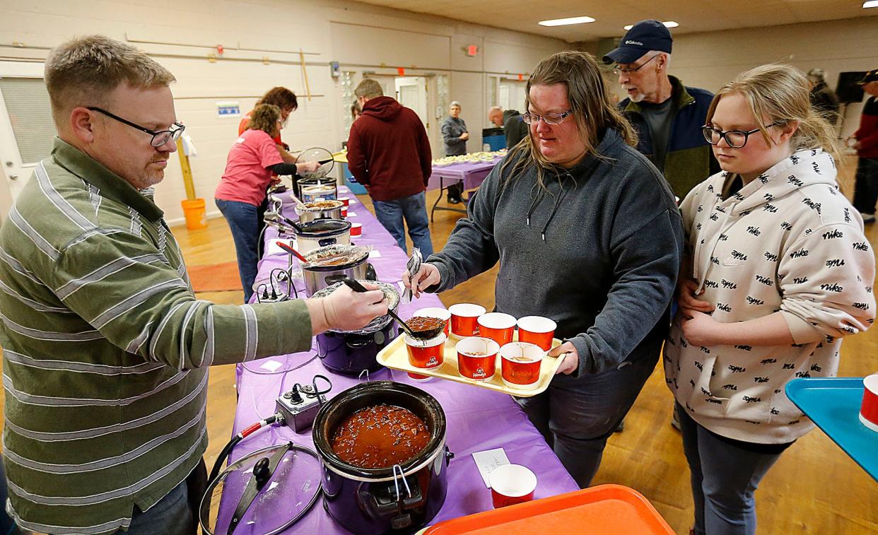 Matthew Bennett serves chili to Heather Hartsel and Summer Kramer at Relay For Life of Ashland County-Mid Ohio's chili cook-off Friday evening at the fairgrounds.