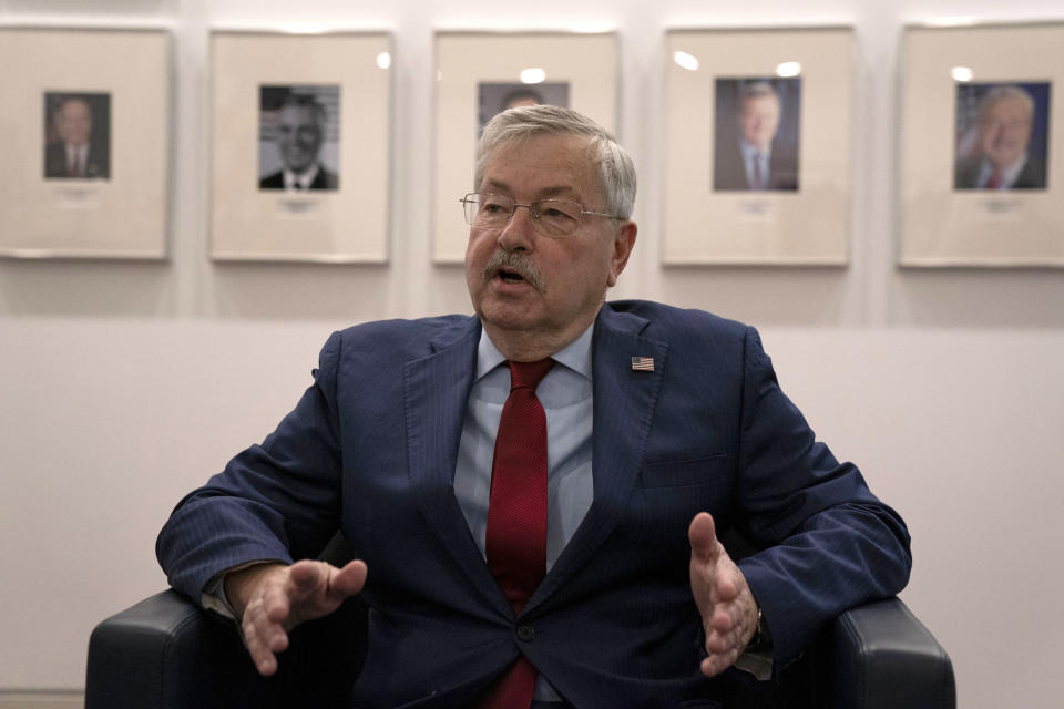 U.S. Ambassador to China Terry Branstad speaks near a photo wall showing former U.S. ambassadors to China as well as his own portrait during an interview at the U.S. embassy in Beijing on Tuesday, Sept. 29, 2020. The departing U.S. ambassador on Tuesday defended a tough approach to China that has riled relations between the world's two largest economies, saying the Trump administration has made progress on trade and that he hopes it will extend to other areas. (AP Photo/Ng Han Guan)