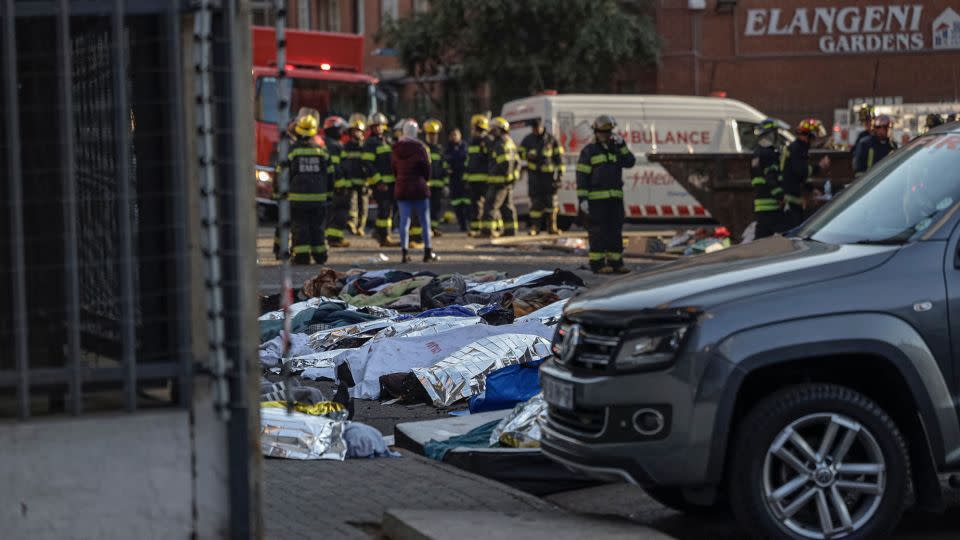 Rescue workers covered bodies in blankets and sheets outside the building. - Michele Spatari/AFP/Getty Images