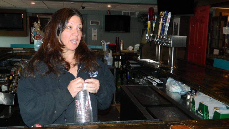 In this March 31, 2014 photo, Gigi Liaguno-Dorr stacks plastic beer cups at Jakeabob's, the Union Beach N.J. restaurant she used to operate until having to close it the previous weekend. The original Jakeabob's was destroyed in Superstorm Sandy, and she moved the business a few blocks inland for 2013. But a continuing inability to get timely rebuilding aid forced her to close the restaurant for good on March 28. The reopening of Jakeabob 's was seen as an inspiration to the still-struggling Raritan Bay community. (AP Photo/Wayne Parry)