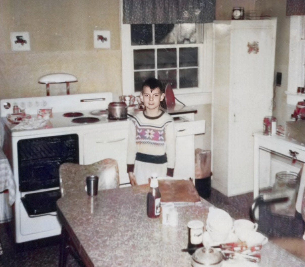 Phillip Seagraves as a child stands  in the kitchen where his mother prepared the foods that the Seagraves family remembers so well.