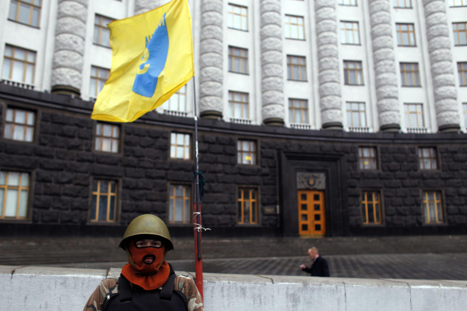 A protester guards the Ukrainian government building in Kiev, Ukraine, Sunday, Feb. 23, 2014. The Kiev protest camp at the center of the anti-President Viktor Yanukovych movement filled with more and more dedicated demonstrators Sunday morning setting up new tents after a day that saw a stunning reversal of fortune in a political standoff that has left scores dead and worried the United States, Europe and Russia. (AP Photo/ Marko Drobnjakovic)