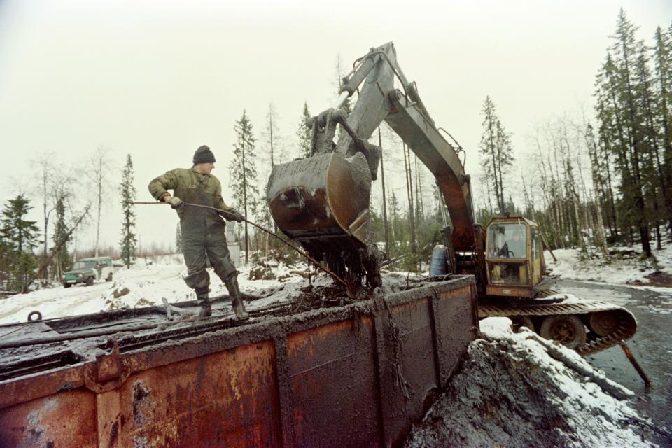 Workers load crude oil into a container on October 28, 1994 as clean-up work in underway following the spill of 60 000 tonnes of crude oil over a large area around Usinsk, in the remote Komi region.