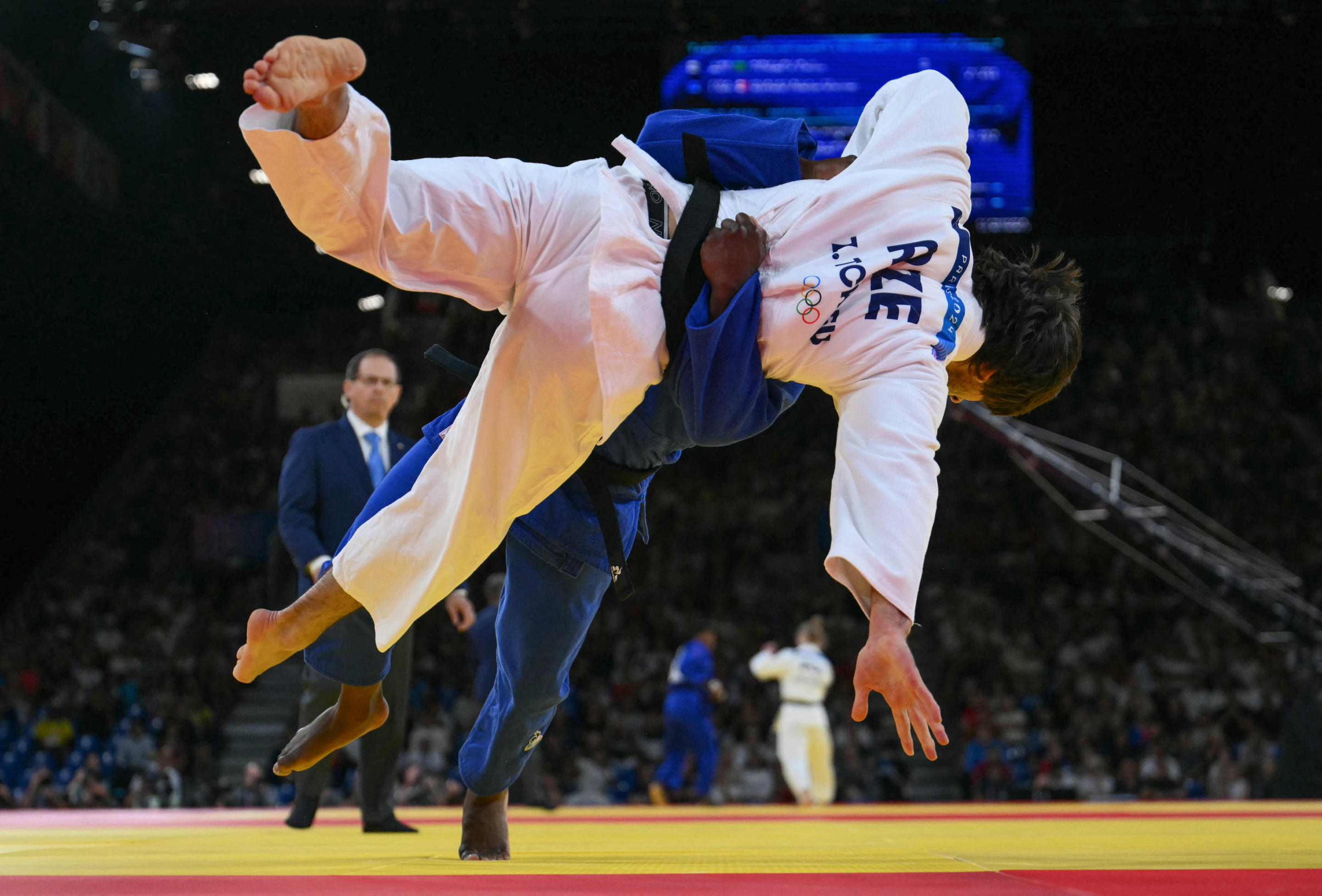 Azerbaijan's Zelim Tckaev and France's Alpha Oumar Djalo (Blue) compete at the judo men's -81kg round of 32 bout of the Paris 2024 Olympic Games at the Champ-de-Mars Arena, in Paris on July 30, 2024. (Luis Robayo/AFP via Getty Images)