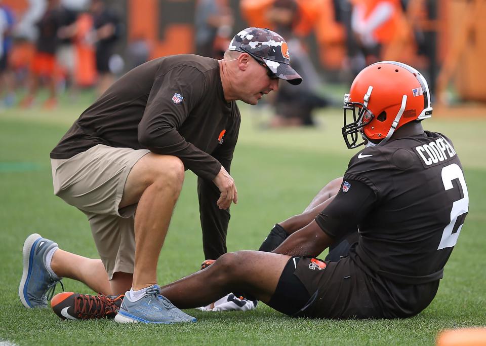 Cleveland Browns wide receiver Amari Cooper, right, is tended to by a trainer after an injury during the NFL football team's football training camp in Berea on Monday.