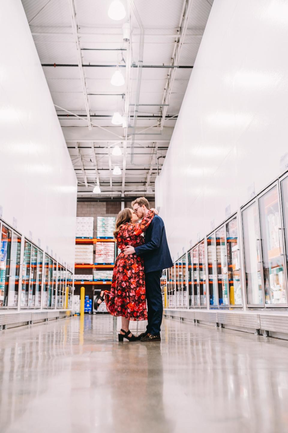 A couple kisses in a grocery store.