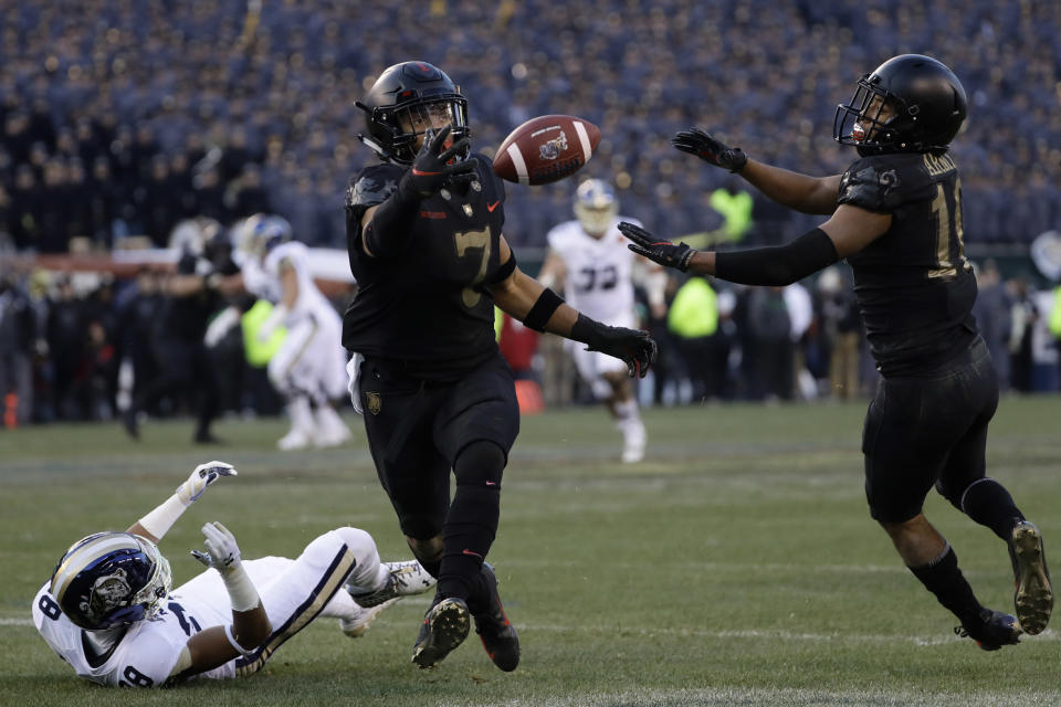 Army's Jaylon McClinton, center, intercepts a pass tipped by teammate Mike Reynolds, right, that was intended for Navy's Mychal Cooper during the first half of an NCAA college football game, Saturday, Dec. 8, 2018, in Philadelphia. (AP Photo/Matt Slocum)