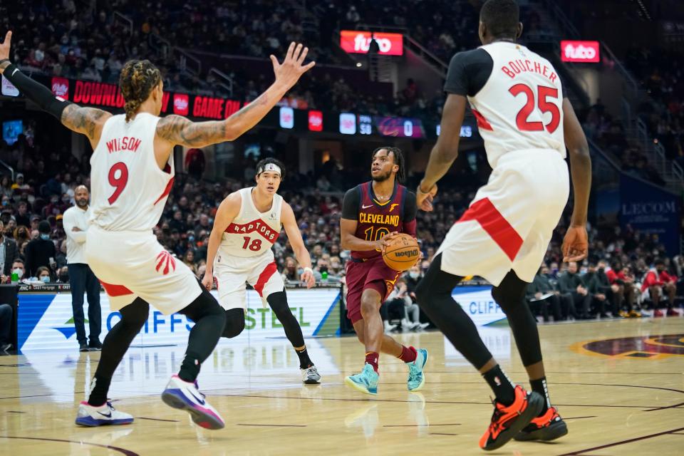 Cavaliers guard Darius Garland (10) drives between Toronto Raptors' D.J. Wilson (9), Yuta Watanabe (18) and Chris Boucher (25) in the first half of the Cavs' 144-99 win Sunday night. [Tony Dejak/Associated Press]