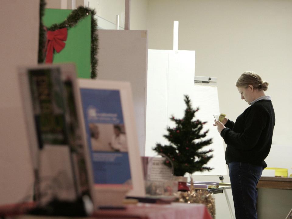 Hope Richardson, a volunteer at the John Wesley United Methodist Church on Old St Augustine Road, organizes items on one of the tables in preparation for the Alternative Christmas Market in 2005. Next weekend, Dec. 1-2, will be the 32nd year for the market.