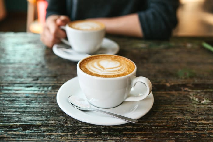 Two cups of coffee on a table.