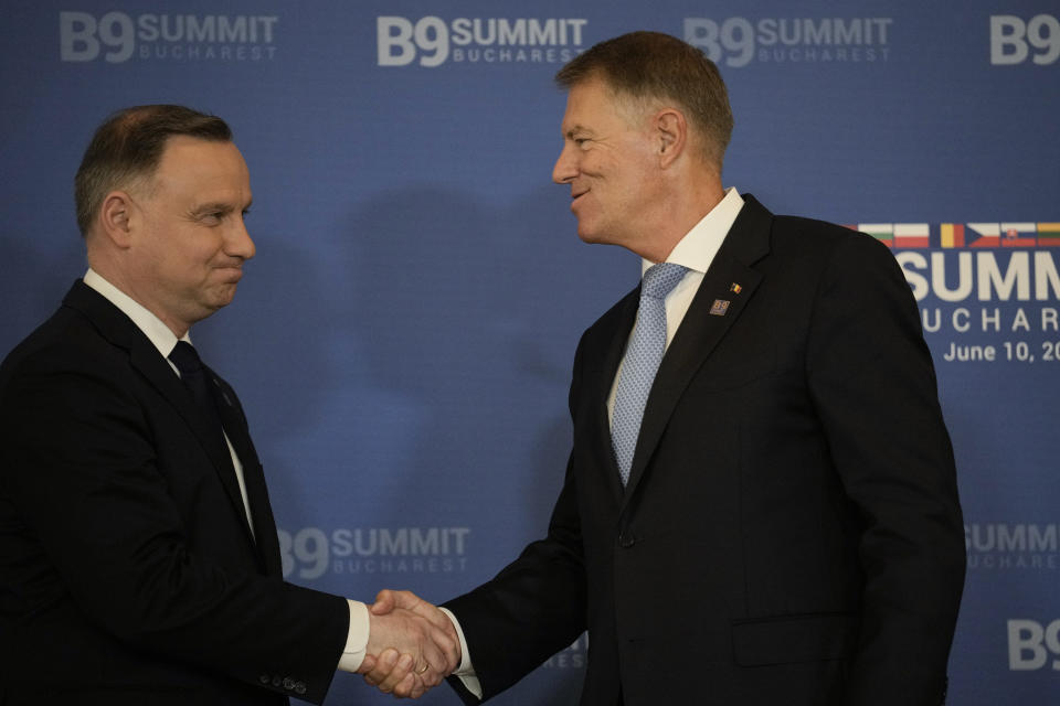 Polish President Andrzej Duda, left, shakes hands with Romania's President Klaus Iohannis at the end of the Bucharest Nine (B9) Summit at the Cotroceni Presidential Palace in Bucharest, Romania, Friday, June 10, 2022. (AP Photo/Vadim Ghirda)