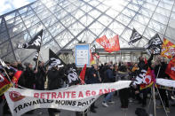 Workers of the culture industry demonstrate outside the Louvre museum Monday, March 27, 2023 in Paris. President Emmanuel Macron inflamed public anger by sending his already unpopular plan to raise the retirement age by two years, from 62 to 64, through parliament without a vote. (AP Photo/Christophe Ena)