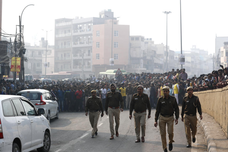 Senior Police officials arrive near the site of a fire in New Delhi, India, Sunday, Dec. 8, 2019. Dozens of people died on Sunday in a devastating fire at a building in a crowded grains market area in central New Delhi, police said. (AP Photo/Manish Swarup)