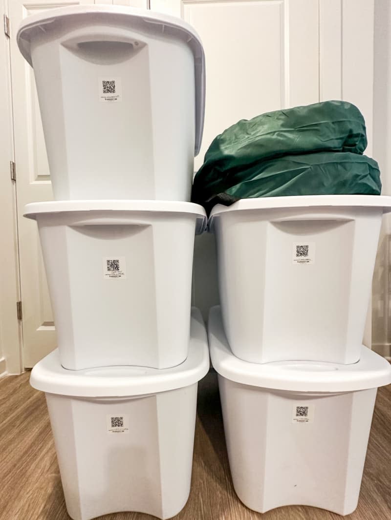 White storage bins stacked with small QR code labels