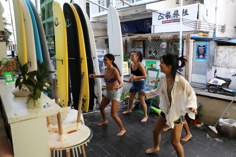 Women exercise during an online gym class at a surfing hotel in Houhai village in Sanya